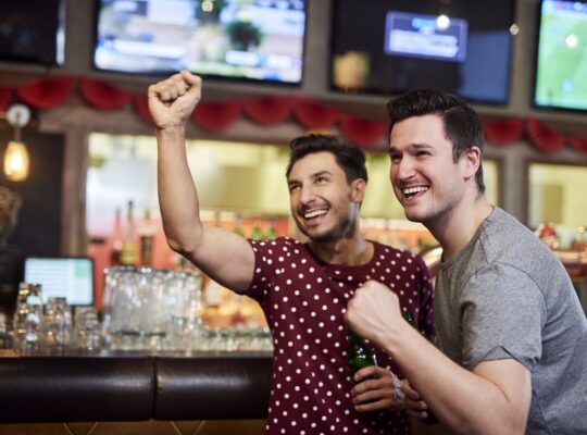 Excited men watching american football competition